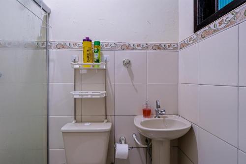 a small bathroom with a toilet and a sink at Casa c Wi-fi e garagem a 5 min do centro in Maricá