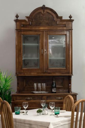 a dining room table with a wooden hutch at Hotel dell'Angelo in Predore