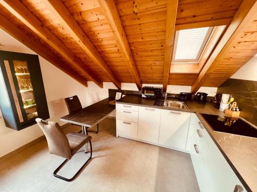 a kitchen with wooden ceilings and a table and chairs at Studio mit King-Size-Bett & Privatparkplatz in Titisee-Neustadt
