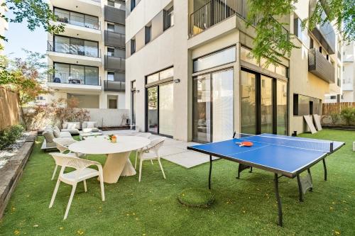 Una mesa de ping pong en el patio trasero de un edificio. en Luxury 3BR Sea View and Pool, en Tel Aviv