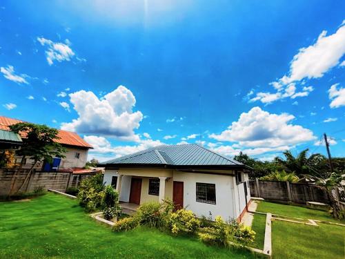 a small white house with a green yard at Résidence N in Kribi