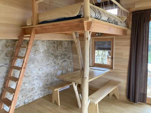 una casa sull'albero con un letto a castello e una scrivania di Cabane du Canada ad Azerat