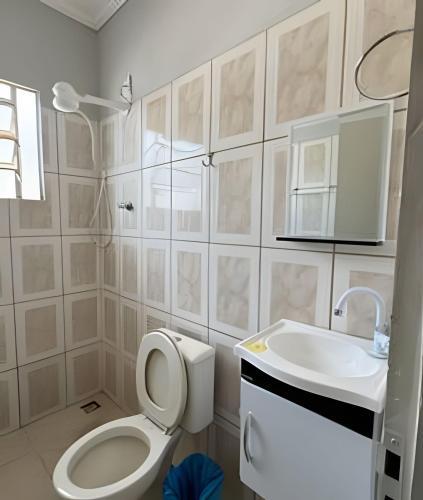 a bathroom with a toilet and a sink at Casa Bairro Bosque com 3 quartos in Rio Branco