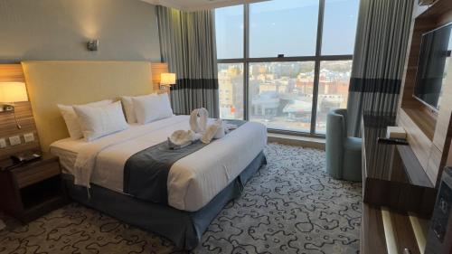 a hotel room with a bed and a large window at فندق الشهباء الفيحاء Hotel Al Shahba Al Faiha Jeddah in Jeddah