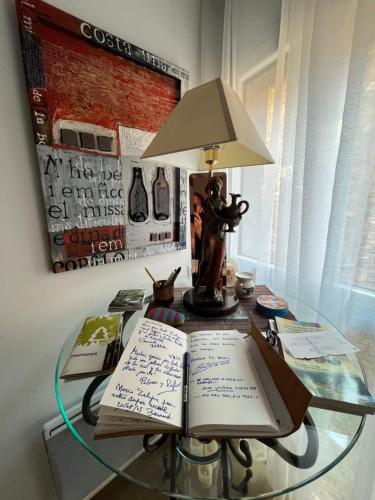 a glass table with a lamp and two books on it at Alojamiento Evelyne Cal Paleta Noves de Segre in Novés de Segre