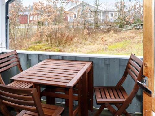 a wooden table and chairs on a porch with a window at 4 person holiday home in Heberg in Heberg