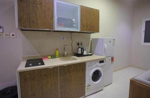 a kitchen with a sink and a washing machine at Dar Hashim Al Nuzha Serviced Apartments - Economic in Riyadh