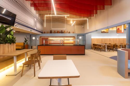 a restaurant with tables and chairs and a cafeteria at ibis Styles Fortaleza Shopping Giga Mall in Fortaleza