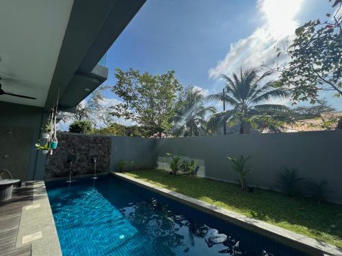 a swimming pool in a backyard with a fence at Malibu 2BR Villa - Private Pool Langkawi in Pulau Tepur