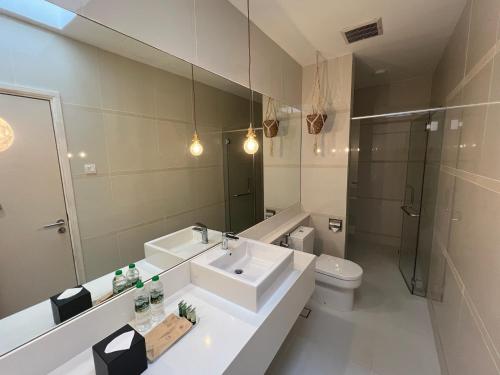 a bathroom with a sink and a toilet and a mirror at Malibu 2BR Villa - Private Pool Langkawi in Pulau Tepur