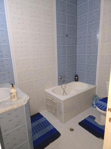 a white bathroom with a tub and a toilet at Appartement de plage f in As Suwaysah