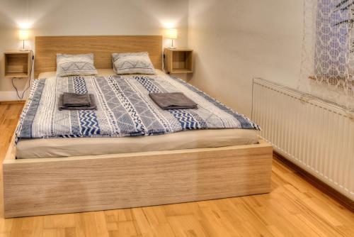 a bedroom with a large bed with a wooden headboard at Apartmány pod Divadlem in Znojmo