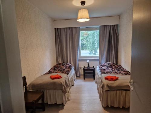 a hotel room with two beds and a window at Myllymäki 22 X in Lahti