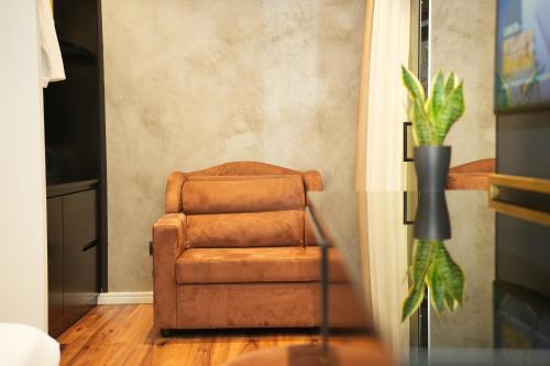 a brown chair sitting in a living room at La Suite Boutique Hotel in Tirana