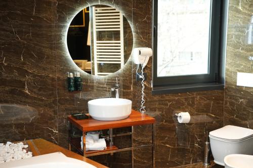a bathroom with a sink and a mirror at La Suite Boutique Hotel in Tirana