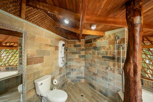 a bathroom with a toilet and a bath tub at Samara Tarantela, Treehouse in Sámara