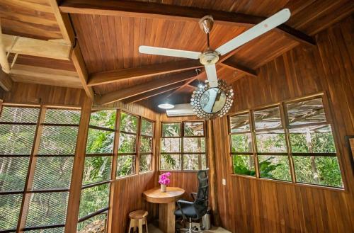 a ceiling fan in a room with windows at Samara Tarantela, Treehouse in Sámara