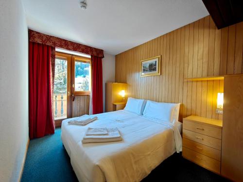 a bedroom with a large bed and a window at Residence Les Coupoles in Champoluc