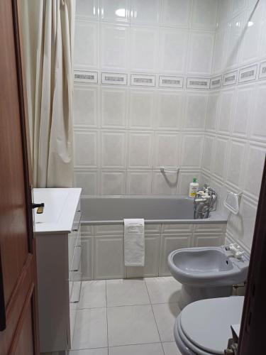 a bathroom with a toilet and a sink and a tub at Casa Na Vila in Vila Pouca de Aguiar