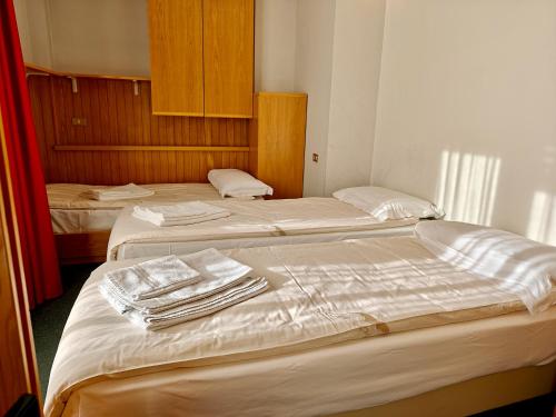 two beds in a hotel room with towels on them at Residence Les Coupoles in Champoluc