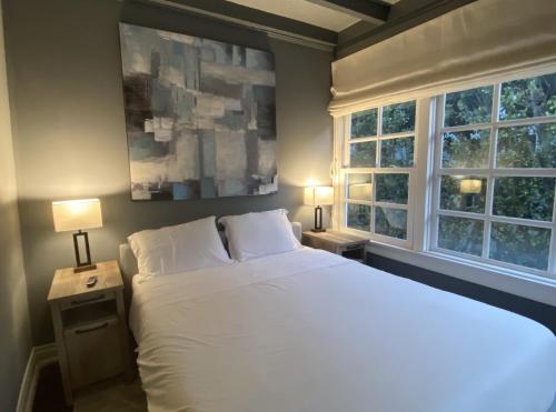 a bedroom with a white bed and two windows at Villa with Heated Pool & SPA in Los Angeles