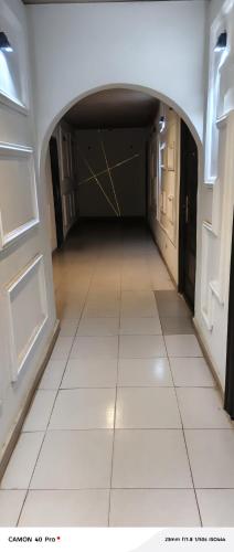 an empty hallway with a white tile floor and doors at AP Luxury Inn in Idowu