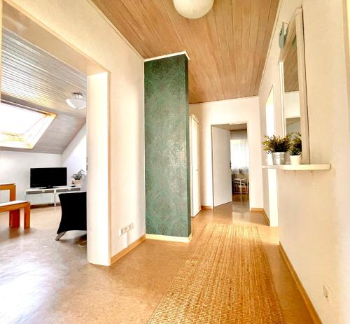 ein Wohnzimmer mit einem Flur mit einer grünen Wand in der Unterkunft -Am Pfühlpark- Ferienwohnung in Heilbronn
