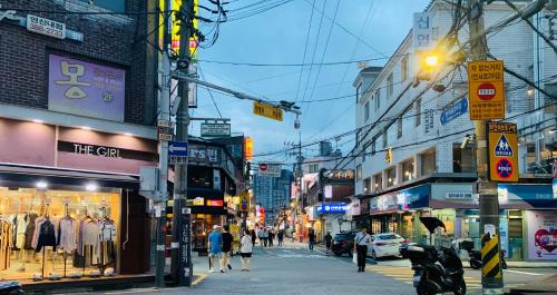 a busy city street with people walking down the street at Cozy Erin Stay, Seoul in Seoul