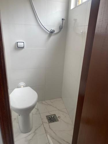 a white bathroom with a toilet and a mirror at Neusa Possar in Sao Paulo