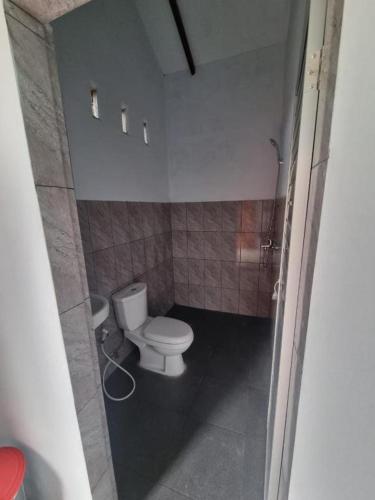 a small bathroom with a toilet and a sink at Sawah Resto Bungalow & Jungle Trekking in Bukit Lawang