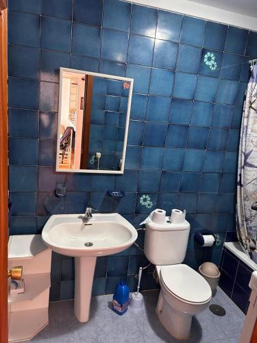 a blue tiled bathroom with a toilet and a sink at Piso Torrox Costa Málaga in Torrox