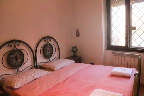 a bedroom with a pink bed with two pillows at B&B Corapi in Rome