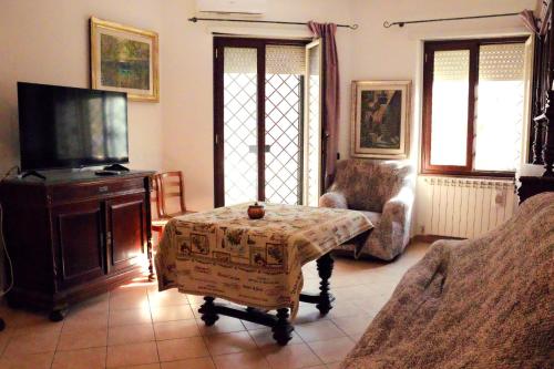 a living room with a couch and a tv and a table at B&B Corapi in Rome