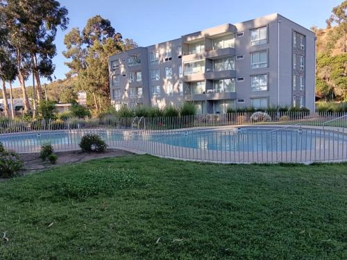 an apartment building with a swimming pool in front of a building at Hermoso departamento, Punta Puyai, Papudo in Petorca