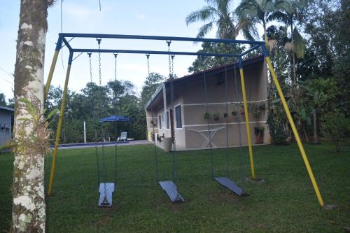 a swing set in a yard with a house at Casa Bela, perfeita para Descanso! in Morretes
