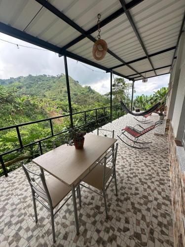 Estación El SaltoにあるAuthentic coffee farmのバルコニー(テーブル、椅子、ハンモック付)