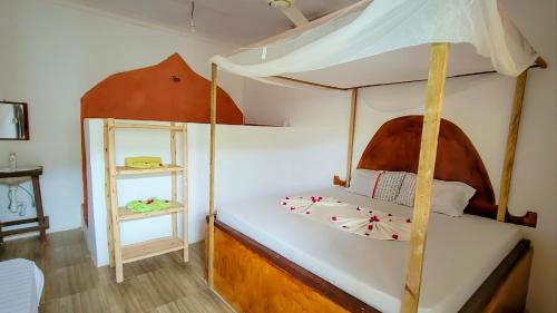 a bedroom with a canopy bed with a mirror at Mufassa Beach Hotel in Jambiani