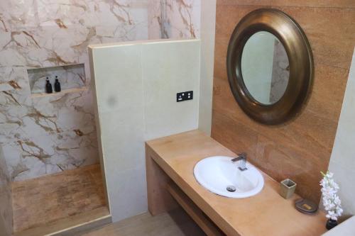 a bathroom with a sink and a mirror at The Spice House Mirissa in Mirissa