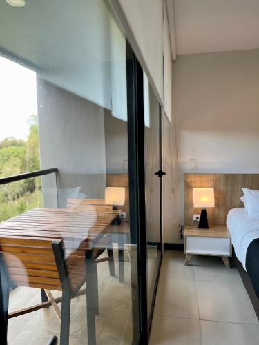 a room with a bed and a table and a bedroom at Hotel Rioverde - Habitación Estándar in Rionegro