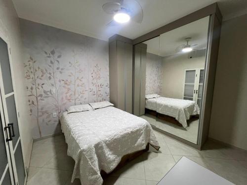 a bedroom with a bed and a large mirror at CASA Vila Braz - Pirassununga, SP in Pirassununga
