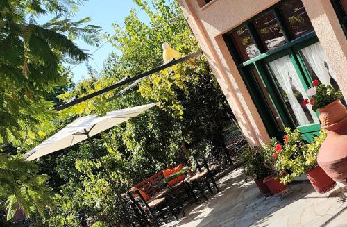 a patio with chairs and an umbrella on a house at Pension Niki in Skála Sykaminéas