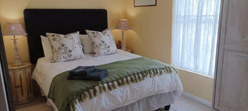 a bedroom with a bed with white sheets and a window at Villa Ulrika - McGregor in McGregor