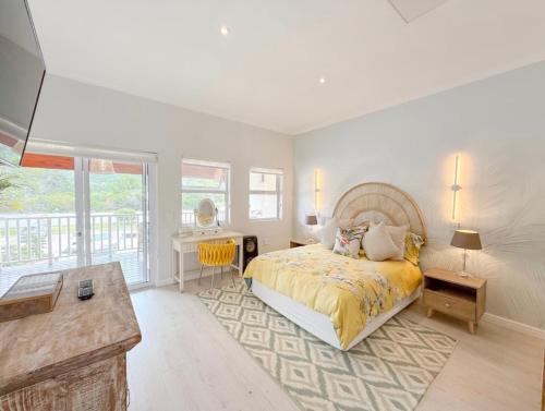 a bedroom with a bed with a yellow bedspread at Coastal Bliss Getaway Awaits! in Keurboomstrand