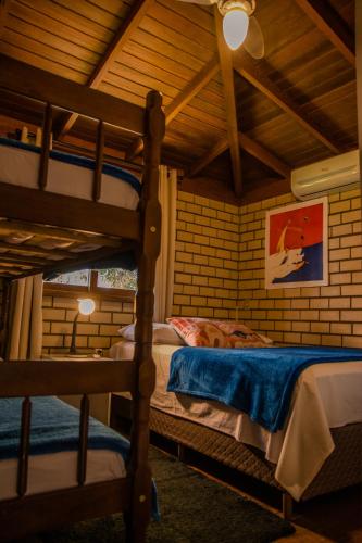 a bedroom with two bunk beds in a attic at Morada Quatro Elementos - 150 Metros do Centrinho in Praia do Rosa