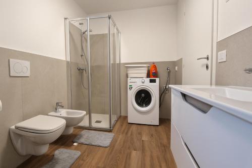 a bathroom with a toilet sink and a washing machine at Cà di Sgarei TA in Nona