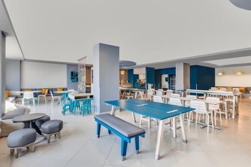 a dining area with tables and chairs in a cafeteria at One Ciudad Juarez Alameda Iglesias in Manuel F. Martínez