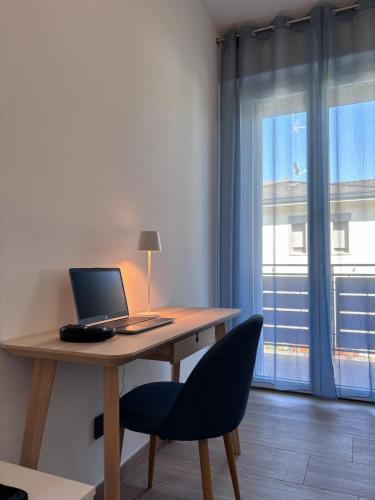a desk with a laptop computer on it next to a window at Casa Mavora in Nonantola