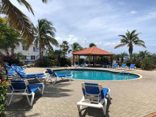 a swimming pool with lounge chairs and a gazebo at Little Slice of Paradise in Westpunt