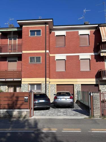 two cars parked in a parking lot in front of a brick building at Casa Mavora in Nonantola