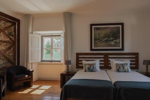 a bedroom with two beds and a window at Quinta do Pinheiro Hotel E Eventos by Grupo Quinta dos Lagos in Valado dos Frades
